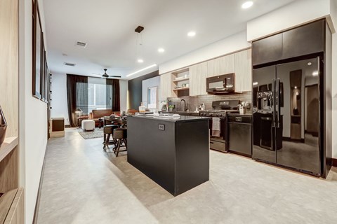 A modern kitchen with a black island in the middle.